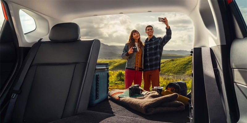 A couple taking a picture of themselves from the back of their Hyundai Kona